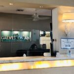 Reception desk at Galveston with clear signage and a cozy lamp.